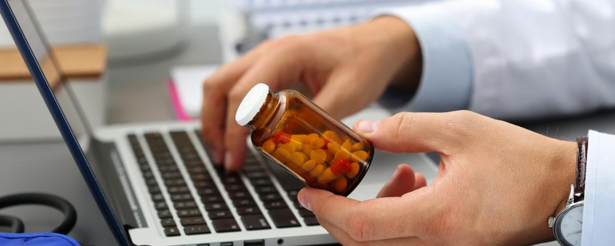 pharmacist looking at bottle of pills