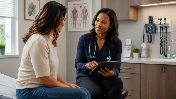 a female doctor and patient talking in an exam room