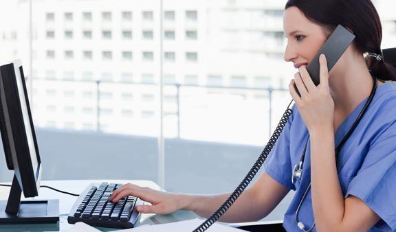 Nurse viewing health data insights on Practice Analytics while on the phone with a patient.