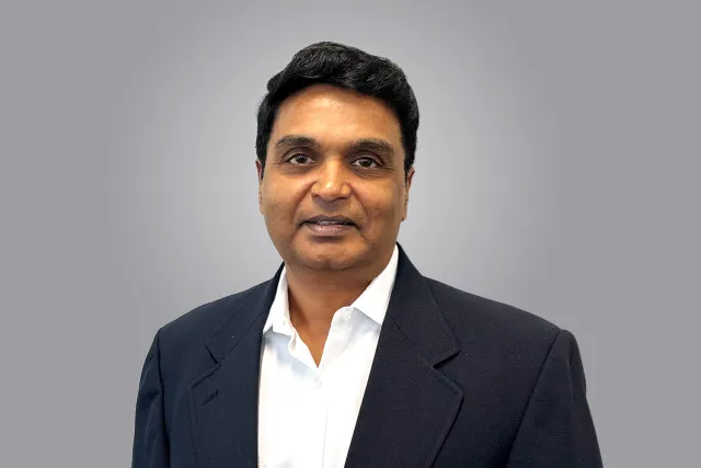 headshot photo of a man in a dark blue suit