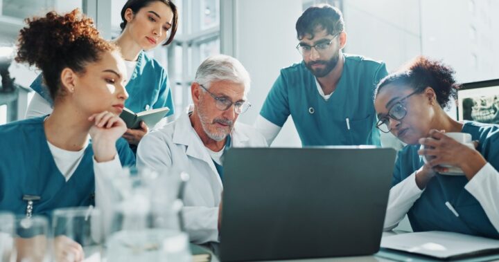 Doctors and nurses meeting with a laptop in a hospital