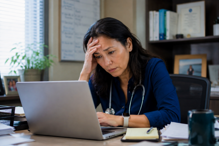 Female doctor looking stressed at her desk